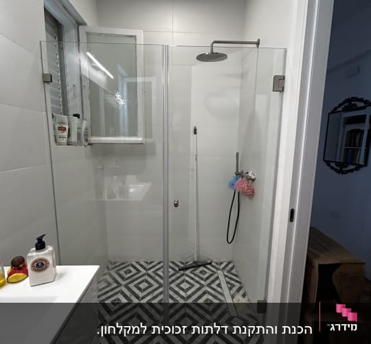 מקלחת עם דלת זכוכית ורצפת אריחים מעוצבת
